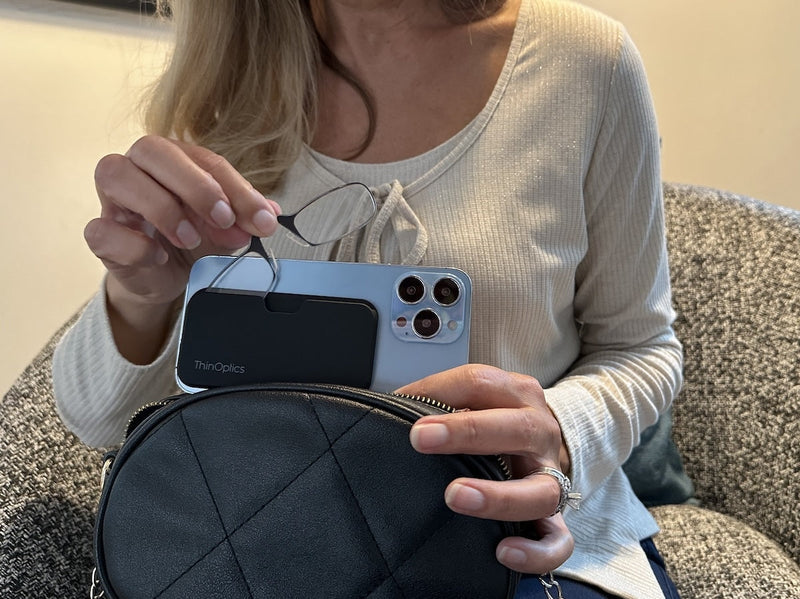 A woman taking out a pair of Readers from a Universal Pod attached to her phone.