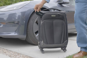 Man putting a ThinOptics Glasses Case in a suitcase.
