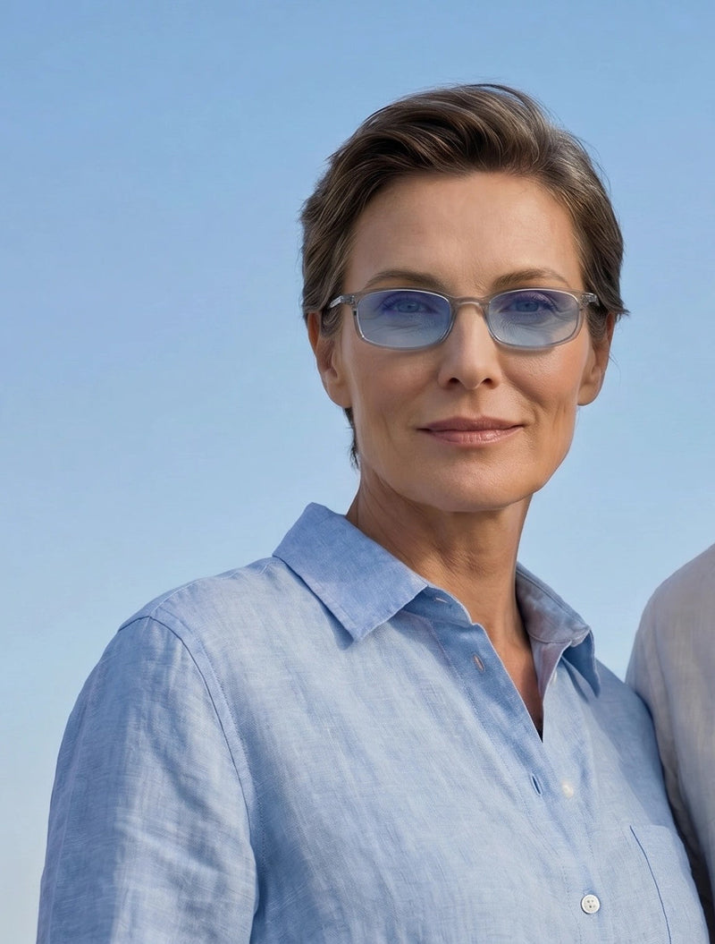 Woman wearing ThinOptics blue light glasses outdoors against a bright blue sky.