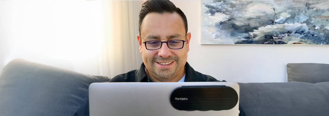 man wearing blue light blockers while working from home on laptop