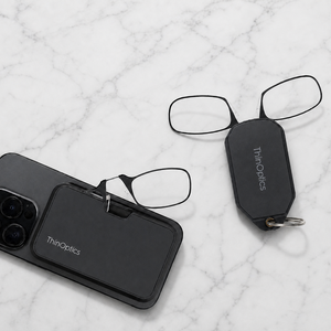 Moment armless readers with black magnetic pod and black keychain case on marble
