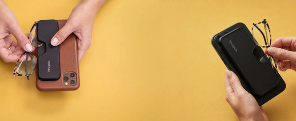 Two hands removing ThinOptics tortoise reading glasses from a ThinOptics phone case — one on a brown iPhone, one on a black iPhone — against a yellow background