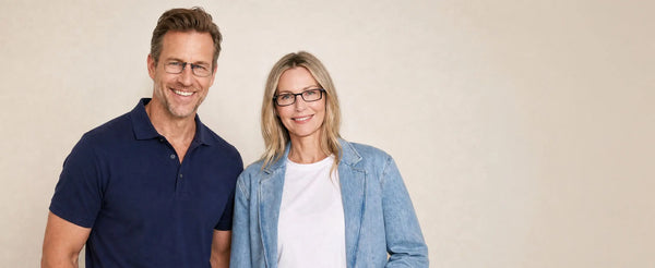Man and woman both wearing ThinOptics rectangle glasses smiling together against a neutral beige background