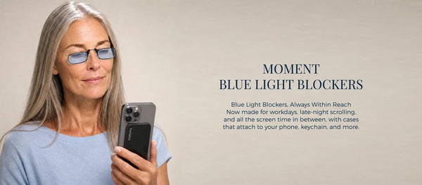 ThinOptics Moment Blue Light Blockers banner featuring a woman wearing armless blue light blocking readers while looking at her phone