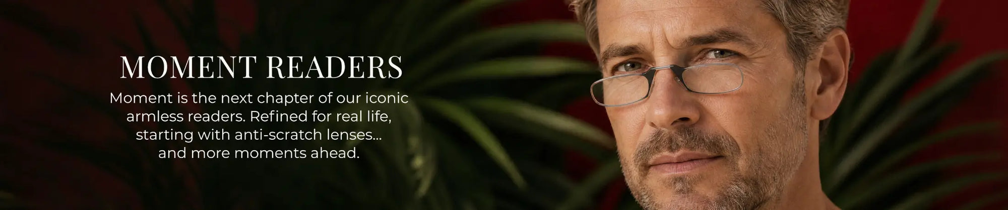 ThinOptics Moment Readers banner featuring a man wearing clear armless reading glasses against a dark red botanical background