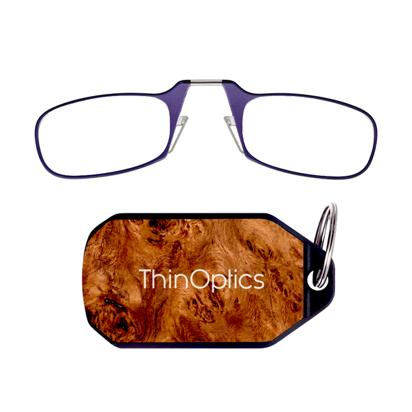ThinOptics purple armless reading glasses above a burlwood keychain case
