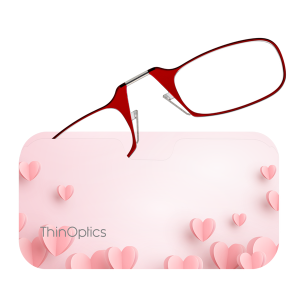 Red ThinOptics Readers peeking out from a Pink Hearts Universal Pod being slipped into a clutch
