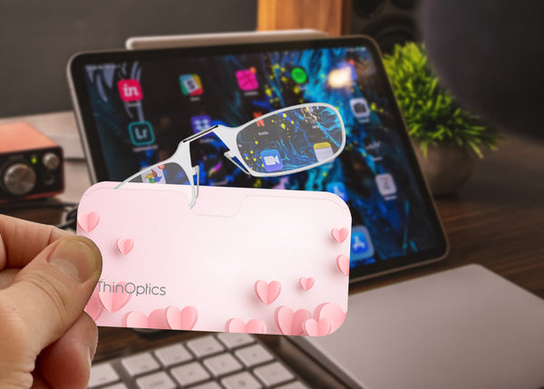 Clear Frames peeking out of a Pink Hearts Universal Pod Case being held up to a screen