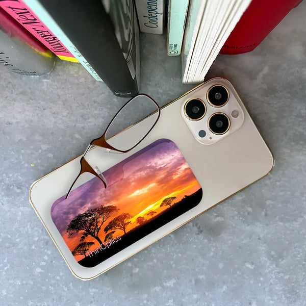 Brown ThinOptics Readers peeking out of a Safari Sunset Universal Pod attached to a phone being held up by a hand