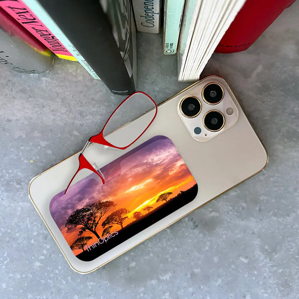 Red ThinOptics Readers peeking out of a Safari Sunset Universal Pod attached to a phone being held up by a hand